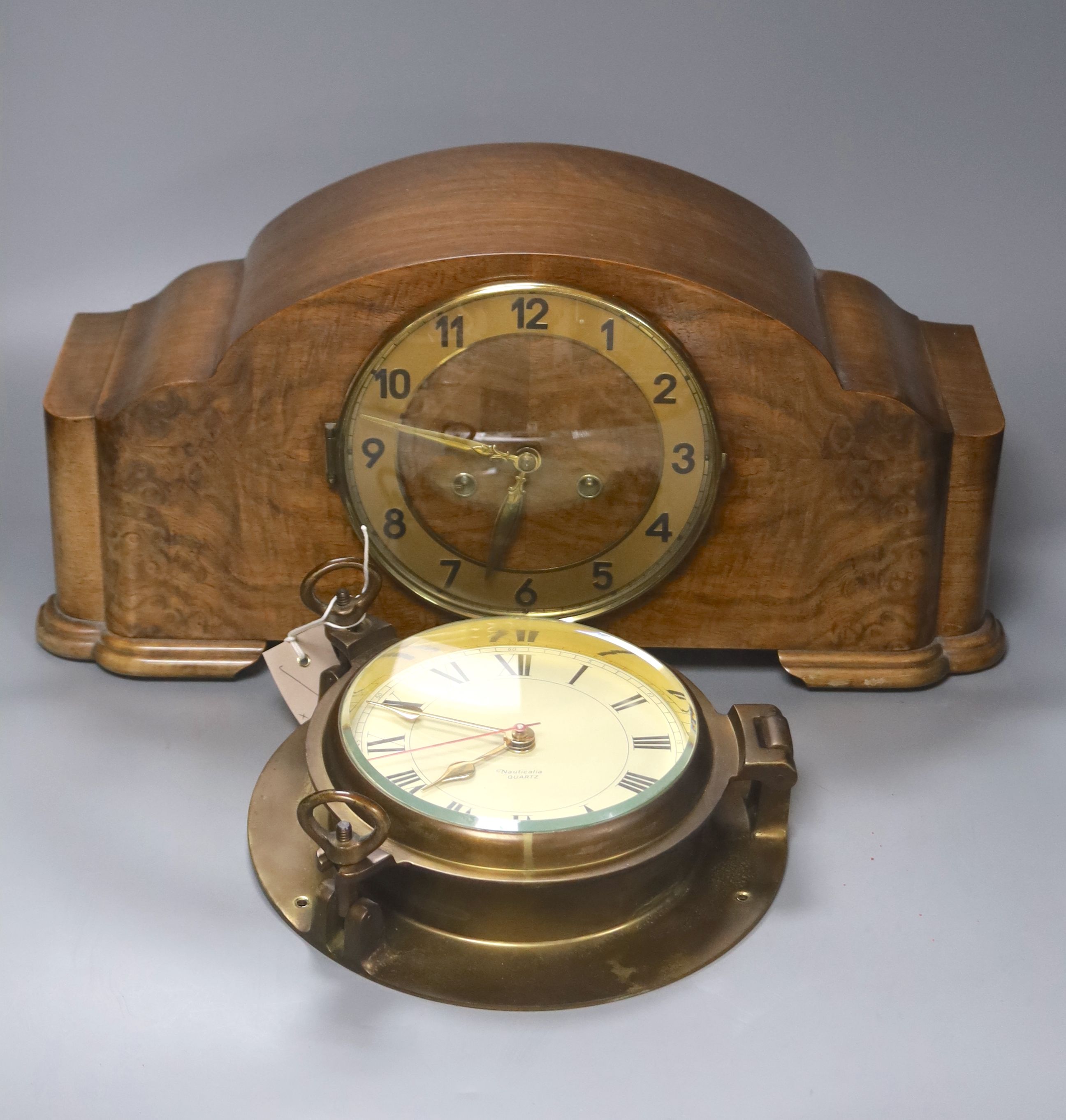 A 1920's walnut cased mantle clock, 42cm wide, 14cm deep, 22cm high and a brass bulkhead wall clock, 22cm diameter.